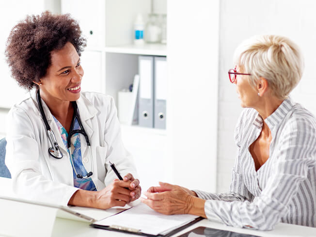 Female cancer doctor smiling at a patient asking a question