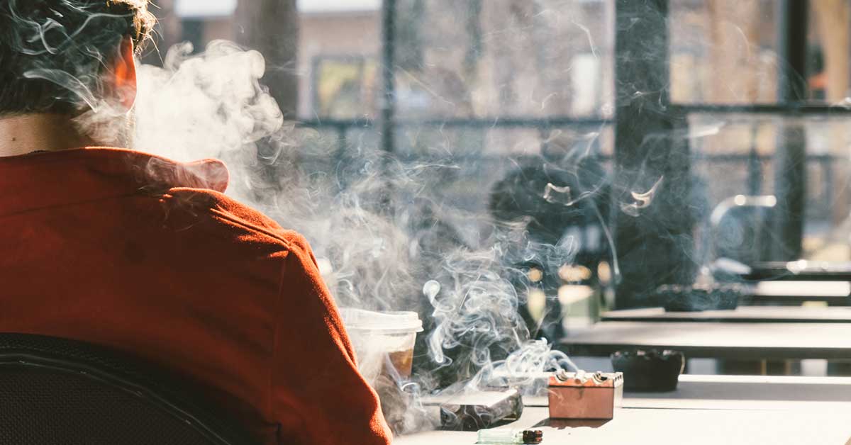 man smoking in a cafe