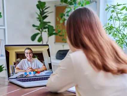 Woman with laptop in virtual therapy appointment