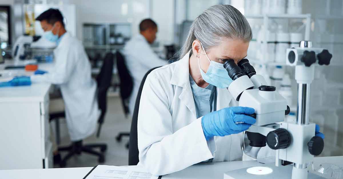 Woman in Lab looking in Microscope