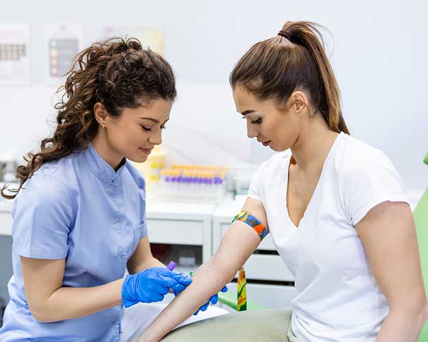 Woman having blood drawn from nurse